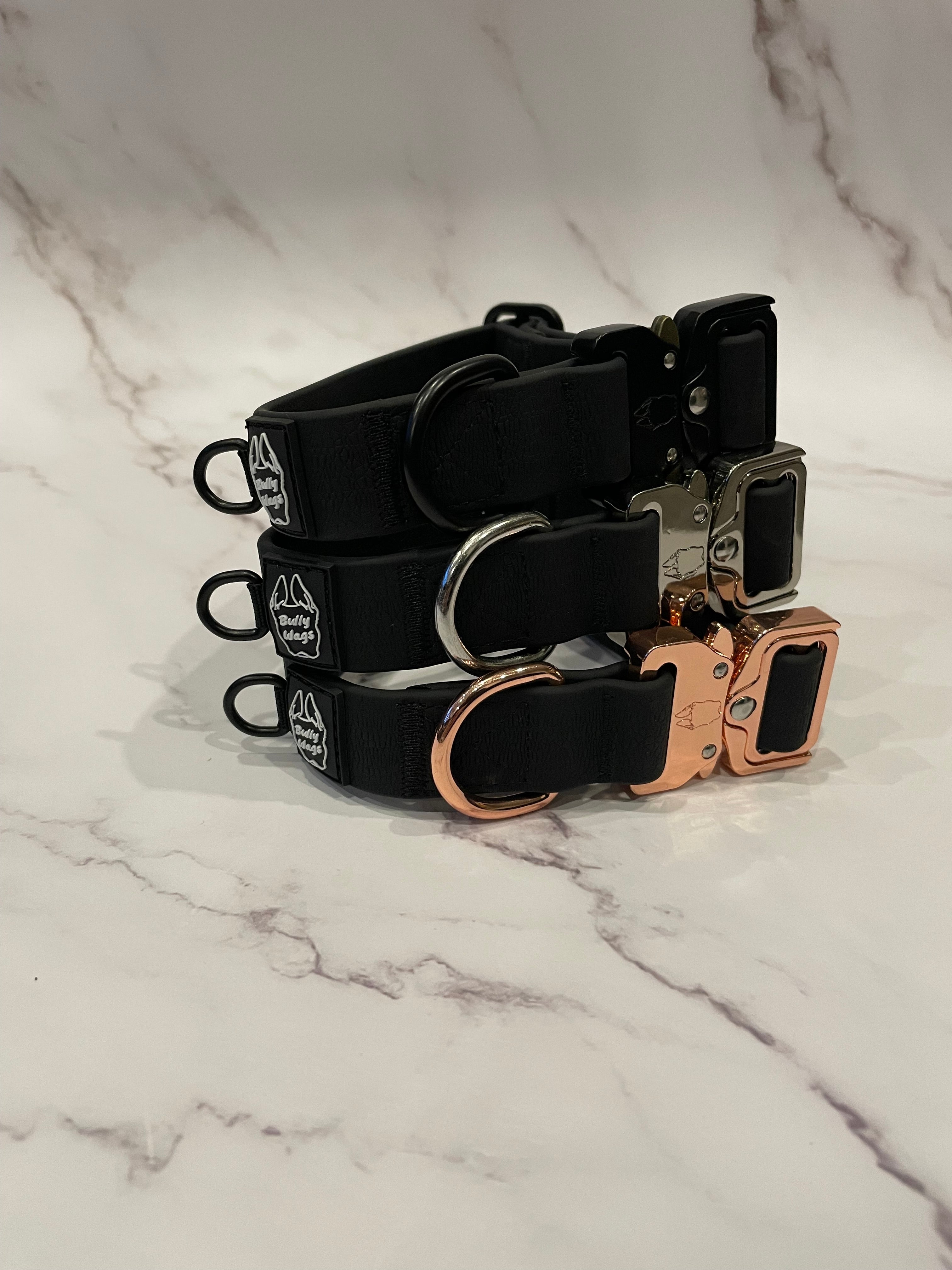 3 black dog collars on a grey background