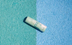 Paw balm tube on a textured blue and green background