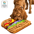 Dog stepping on a colorful snuffle mat shaped like a hot dog with a white background.