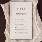 Sheet of paper with 'MATT' branding and features on a textured fabric background