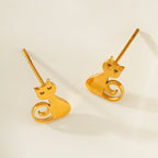 Gold cat-shaped earrings on a light beige background