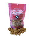 Pink package of freeze-dried salmon treats with visible treats on a white background