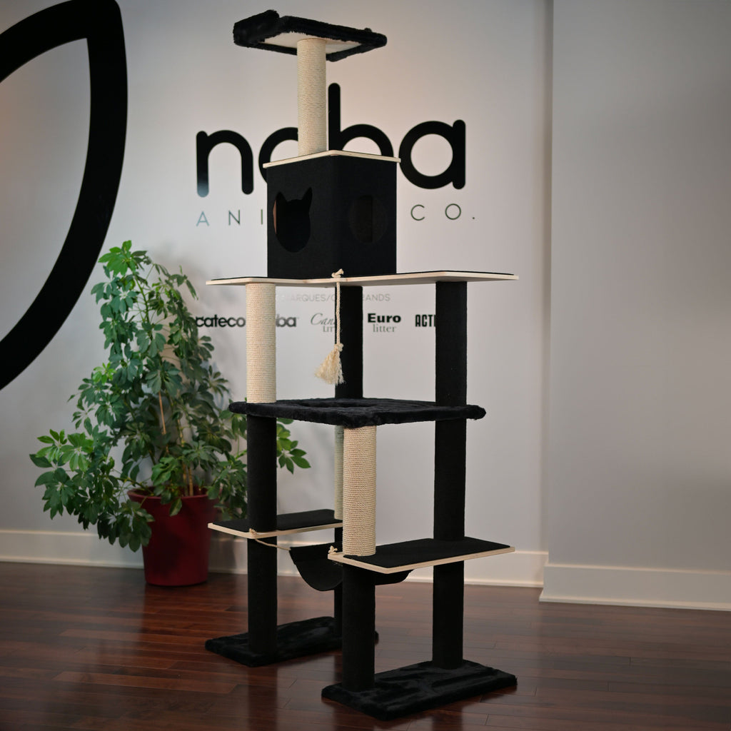 Cat tree with multiple levels and a hammock in front of a branded wall.