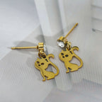 Gold cat-shaped earrings with a clear gemstone on a light gray background