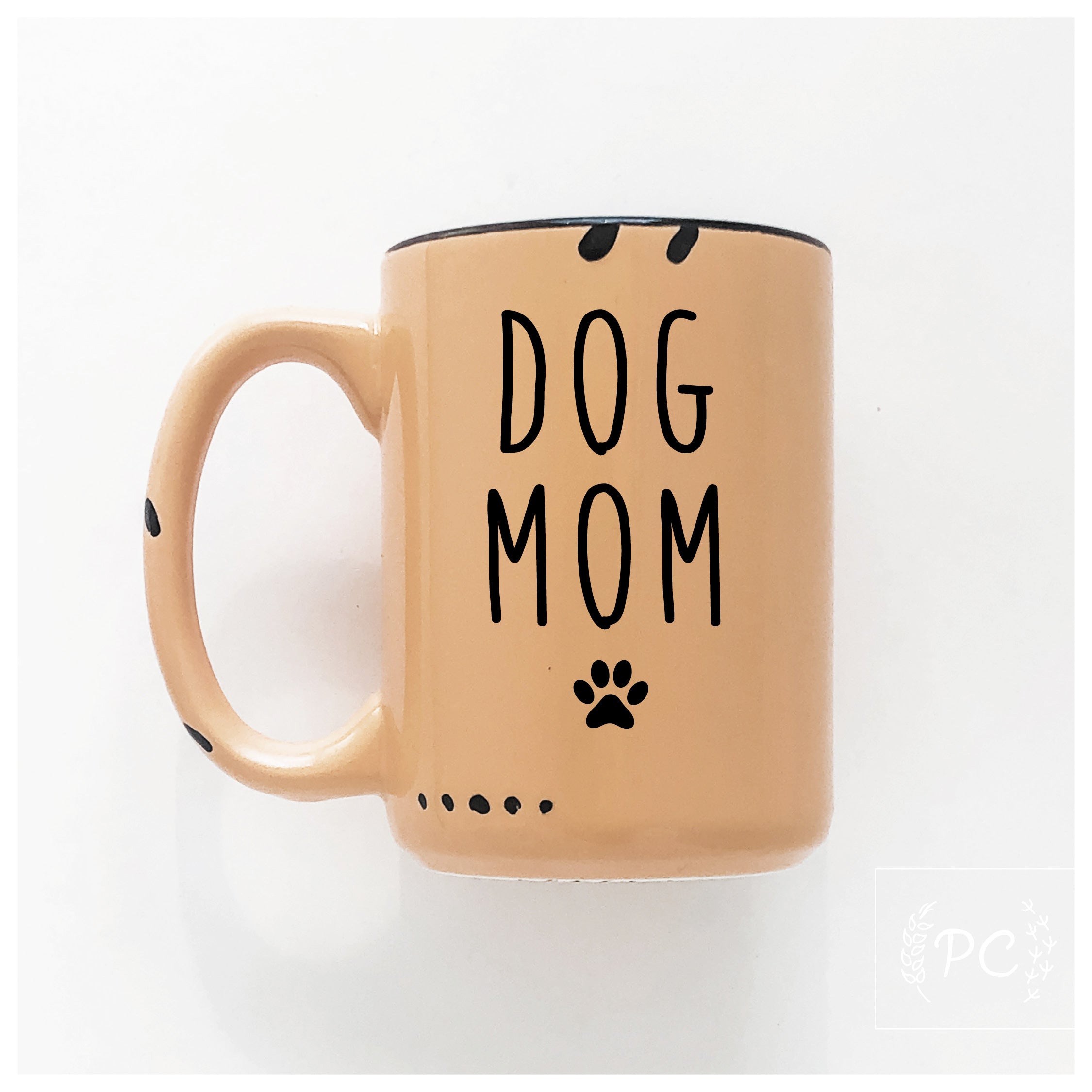 Orange mug with 'DOG MOM' text and paw print on a white background