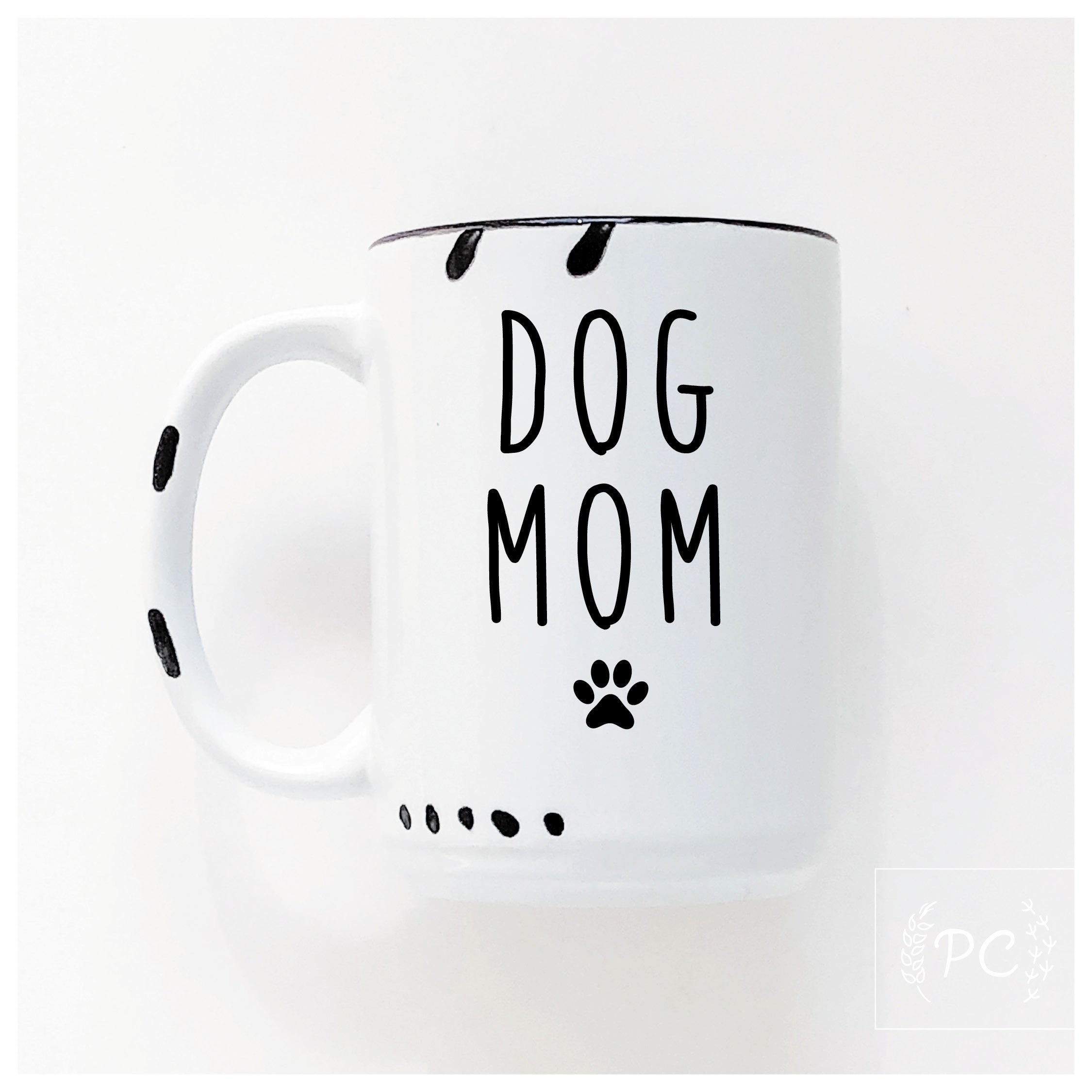 White mug with 'DOG MOM' text and paw prints on a white background