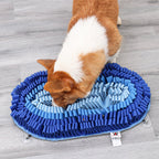 Dog sniffing a blue snuffle mat on a wooden floor