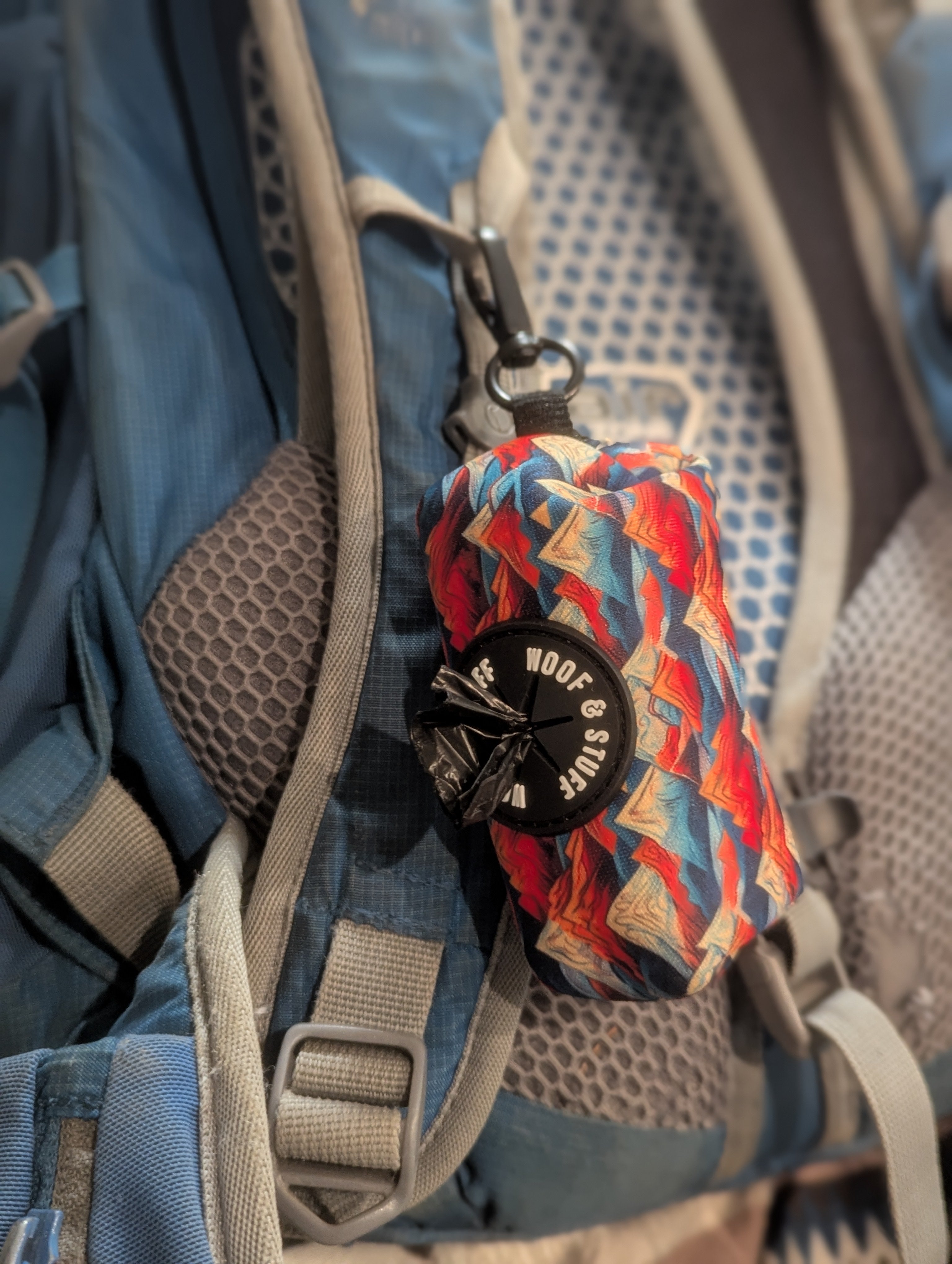 Colorful poop dispenser bag attached to a backpack