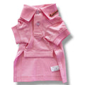 Pink dog polo shirt with a brand label on a white background