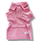 Pink dog polo shirt with a brand label on a white background