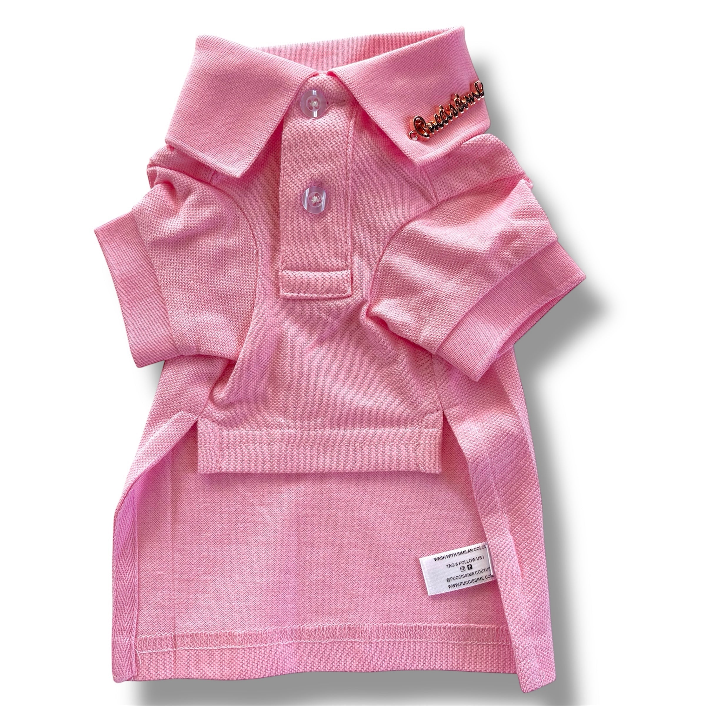 Pink dog polo shirt with a brand label on a white background