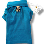 Blue dog shirt with a teddy bear toy and a tag on a white background