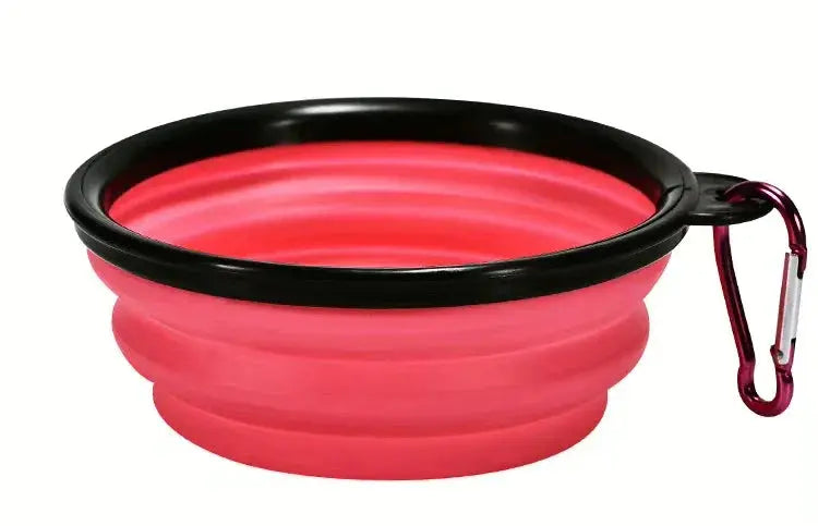 Red silicone travel bowl with black rim and carabiner on a white background