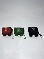 Three small pouches in red, green, and black with keychains on a light gray background