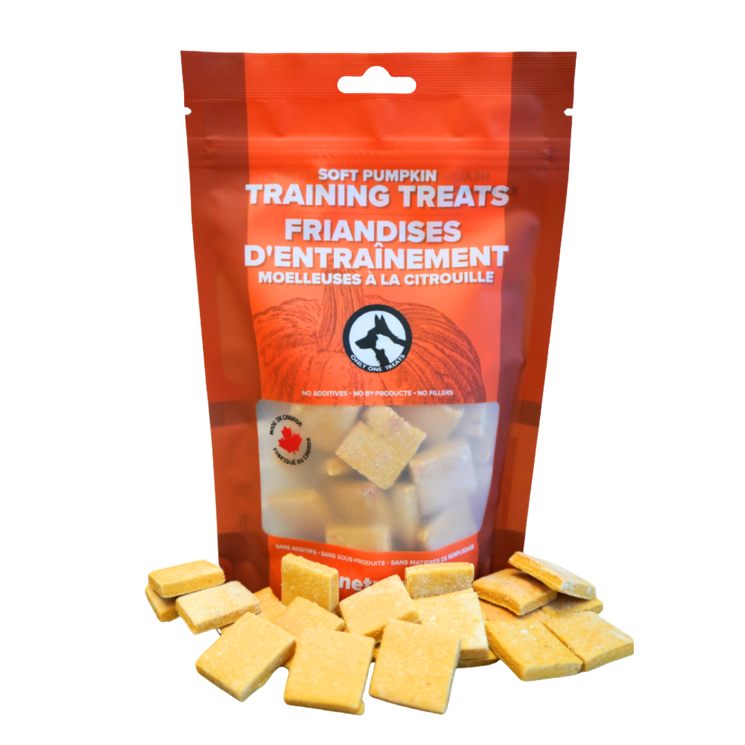 Bag of soft pumpkin training treats with treats spilling out on a white background