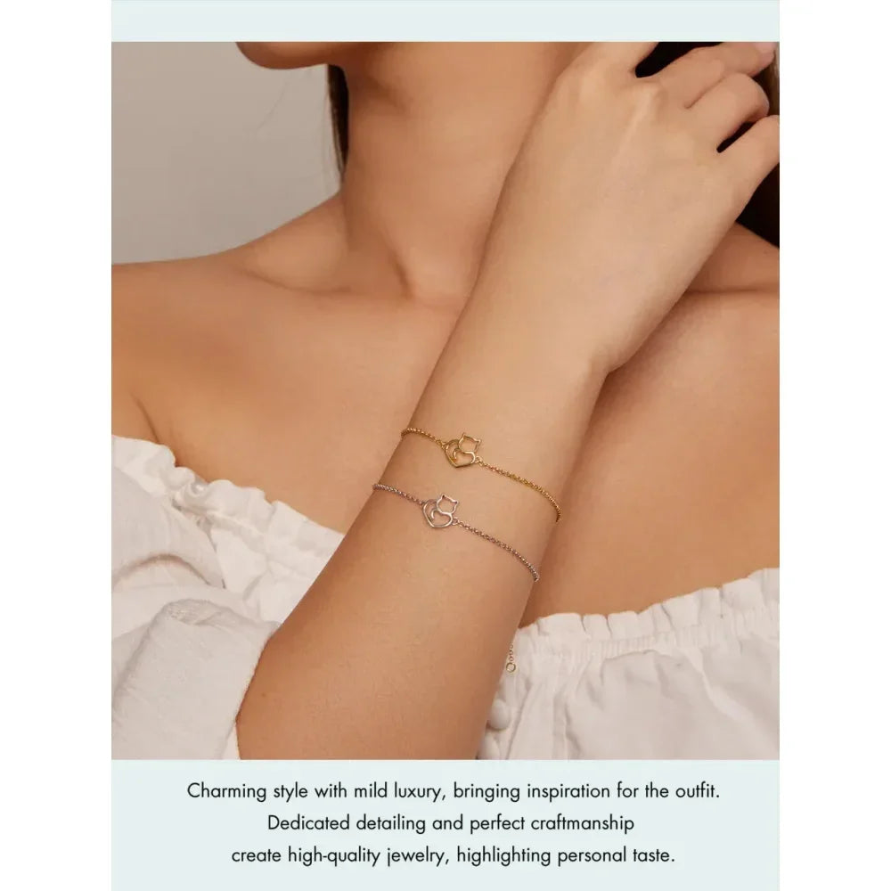 Close-up of a person wearing gold bracelets on a plain background