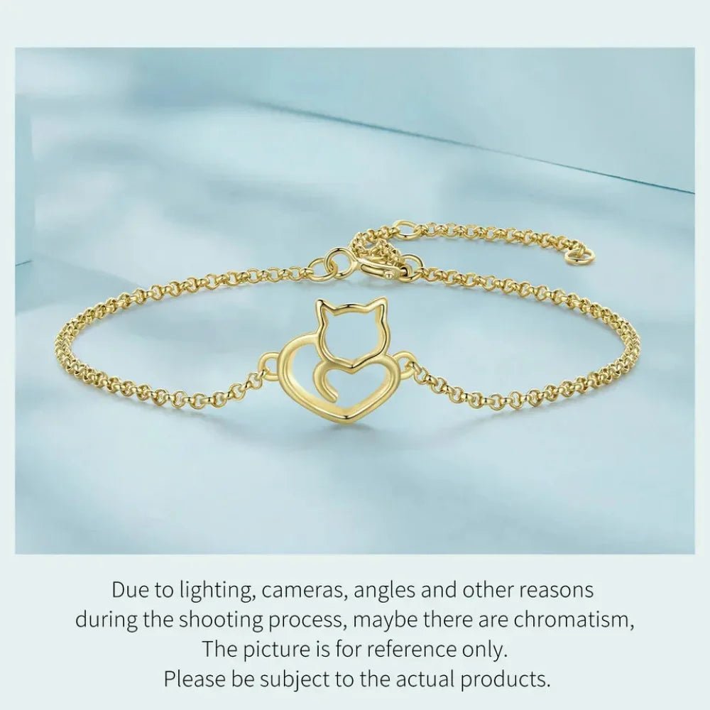 Gold bracelet with a cat-shaped clasp on a light blue background