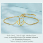 Gold bracelet with a cat-shaped clasp on a light blue background