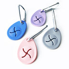 Four oval-shaped poop bag holder with different colors and symbols on a white background