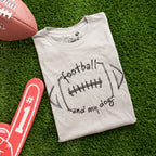Folded t-shirt with 'football and my dog' text on grass with football and foam finger
