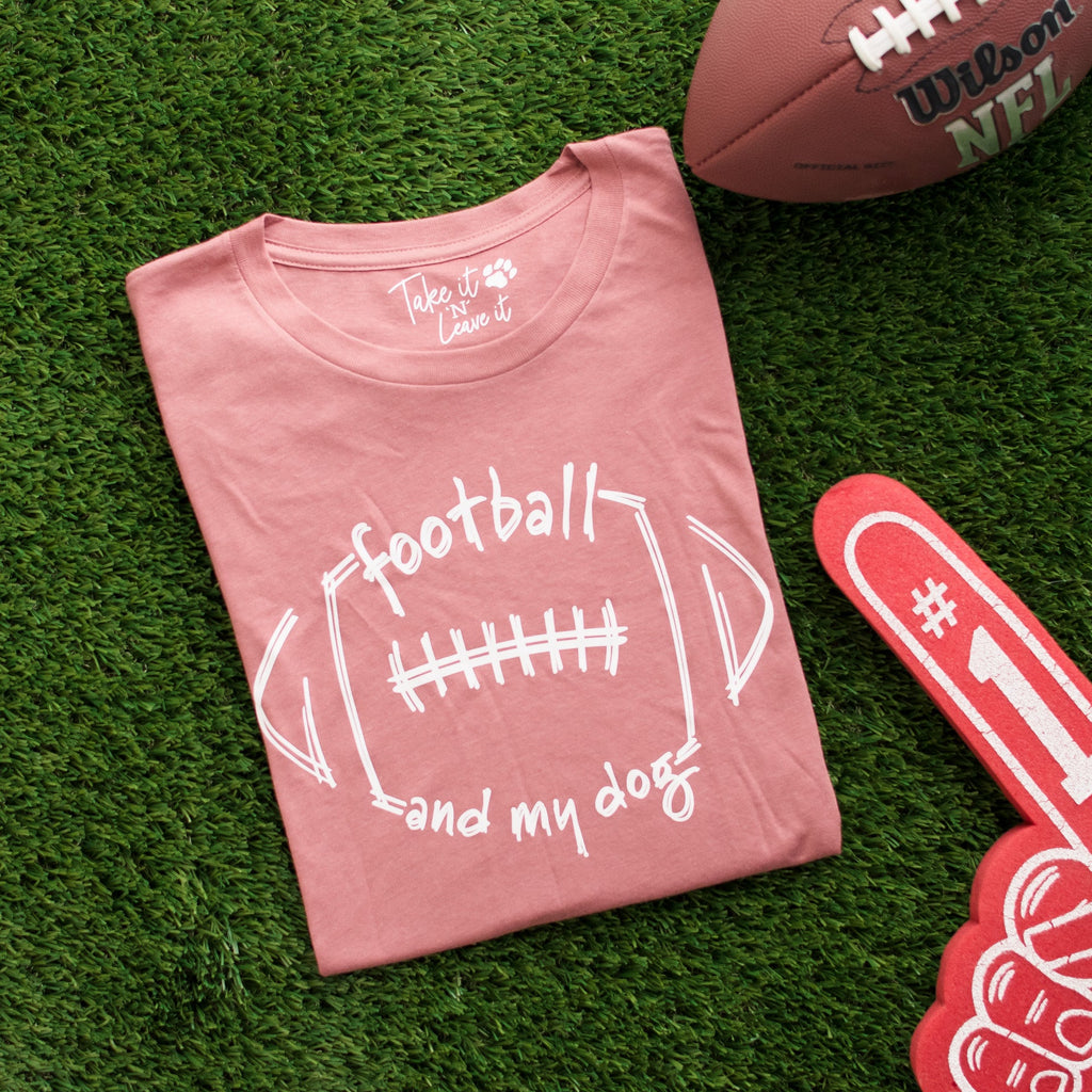 Pink t-shirt with 'football and my dog' text on grass with football and foam finger