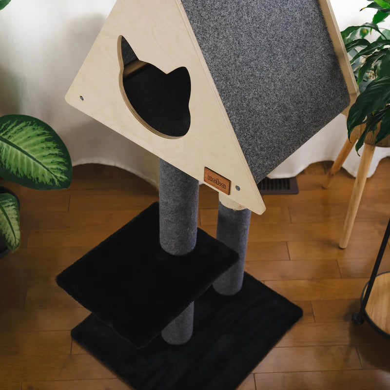 Cat tree with a gray cushioned platform and black base on a wooden floor.