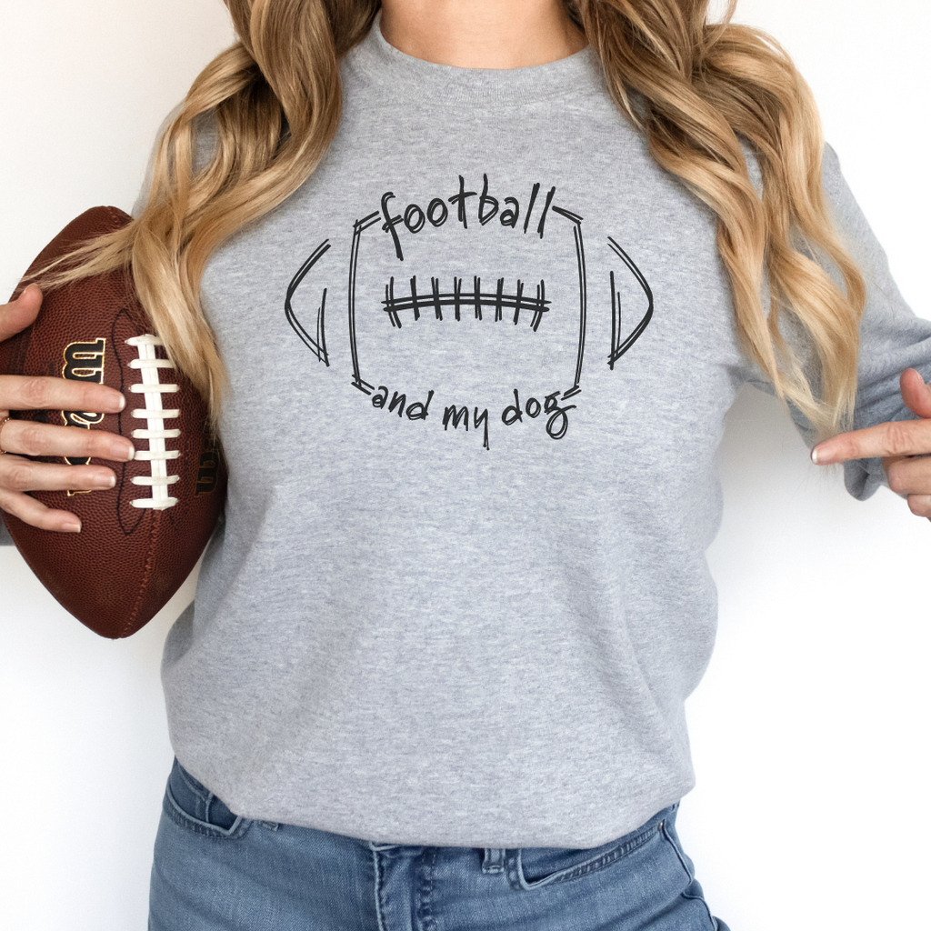 Person wearing a gray sweatshirt with 'football and my dog' text, holding a football.