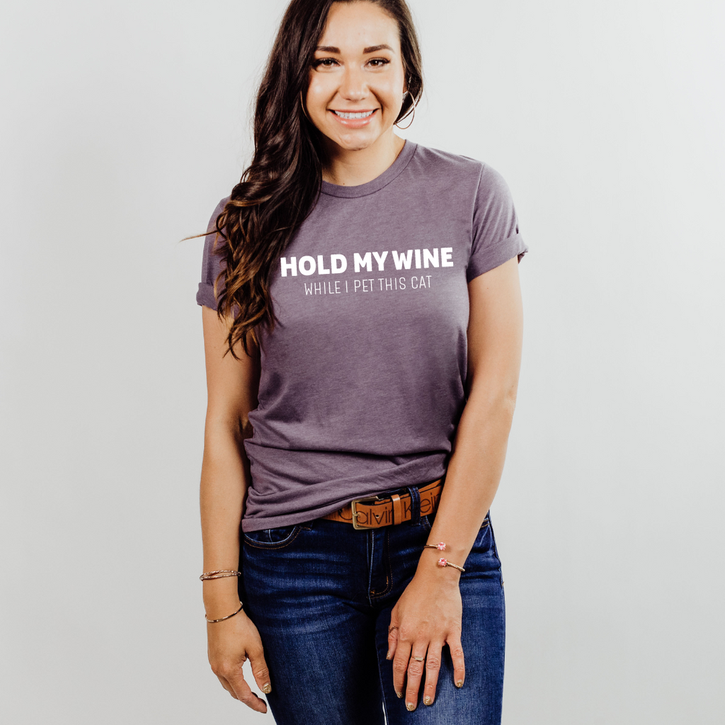 Woman wearing a purple t-shirt with text, standing against a plain background