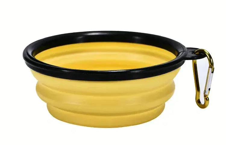 Yellow collapsible dog bowl with black rim and gold carabiner on a white background
