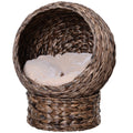 Woven pet bed with a soft white cushion on a white background