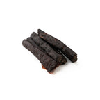 Three dark brown dog chew toys on a white background