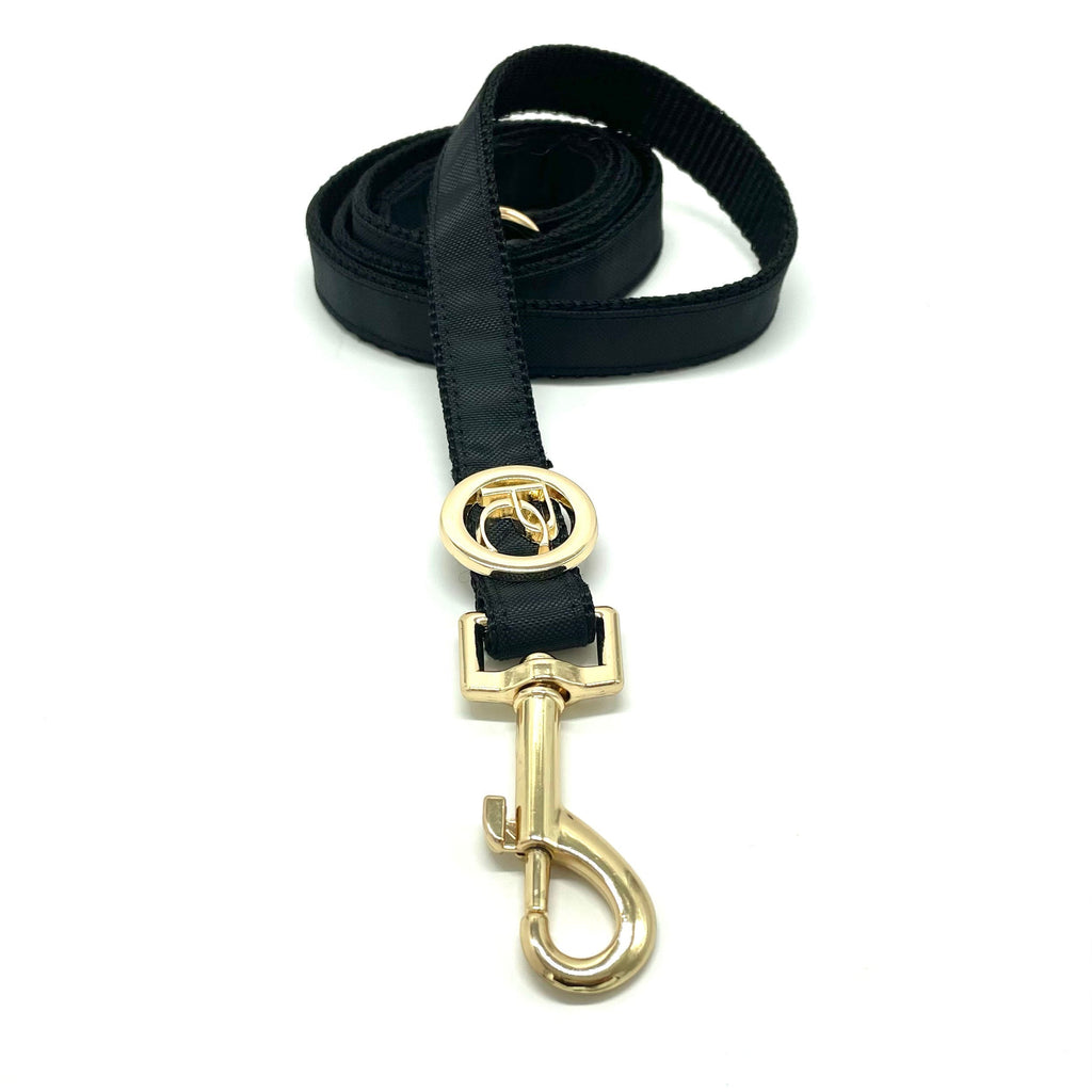 Black dog leash with gold clasp on a white background