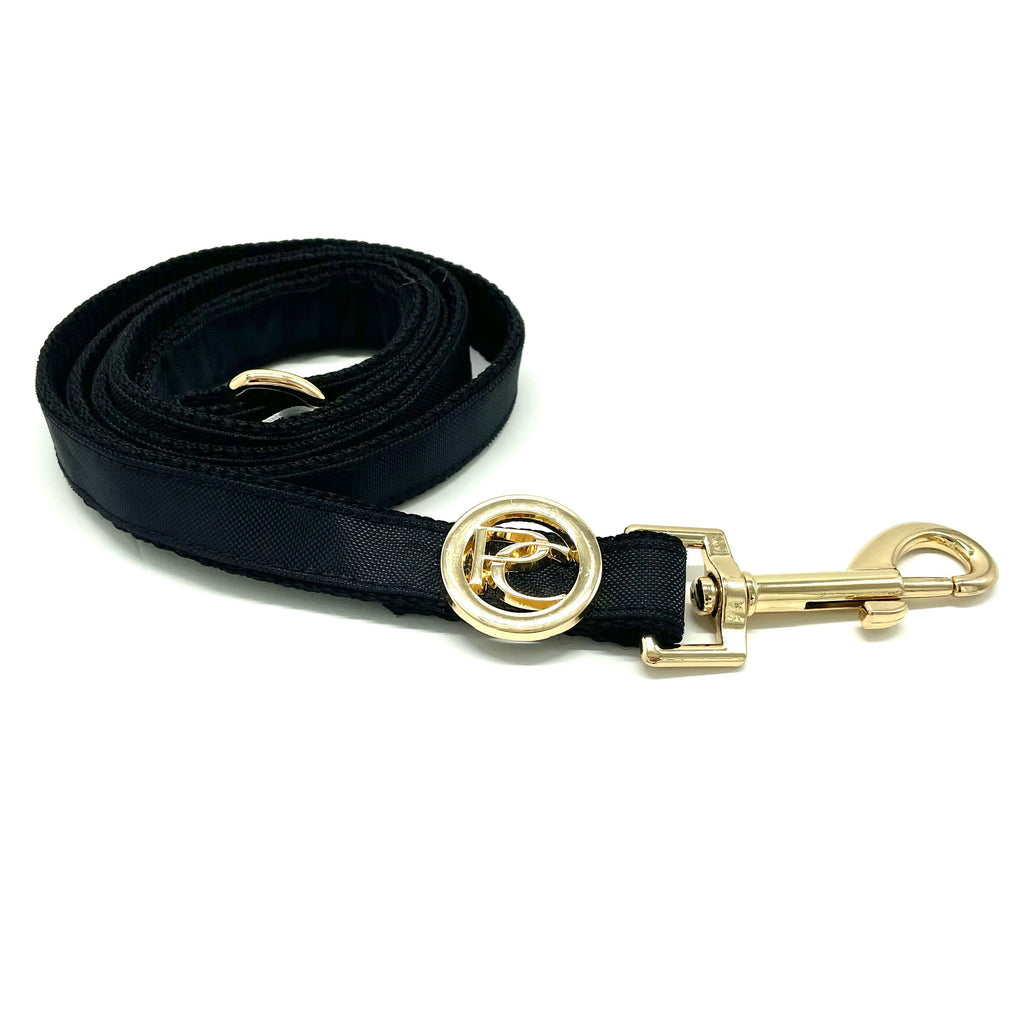 Black dog leash with gold clasp on a white background
