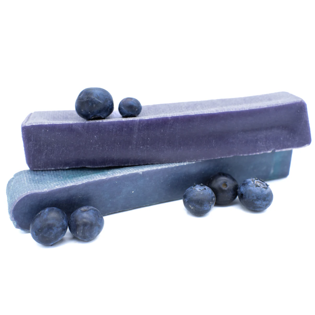 Two blue yak chew with blueberries on a white background