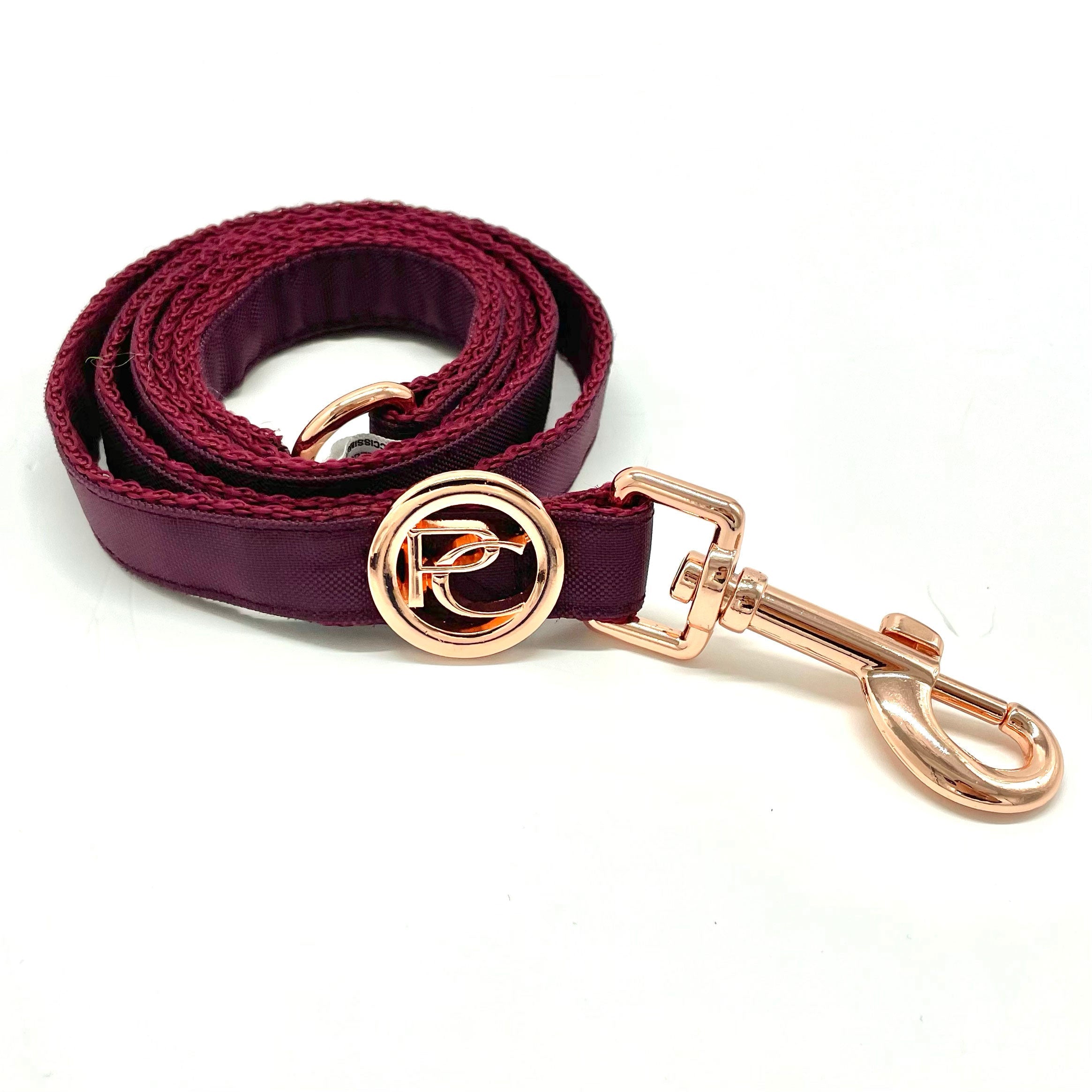 Burgundy dog leash with rose gold clip and hardware on a white background