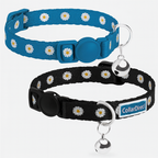 Two cat collars with daisy pattern and bell, one blue and one black, on a white background.