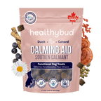 Package of healthybud Calming Aid dog treats with natural ingredients on a green background