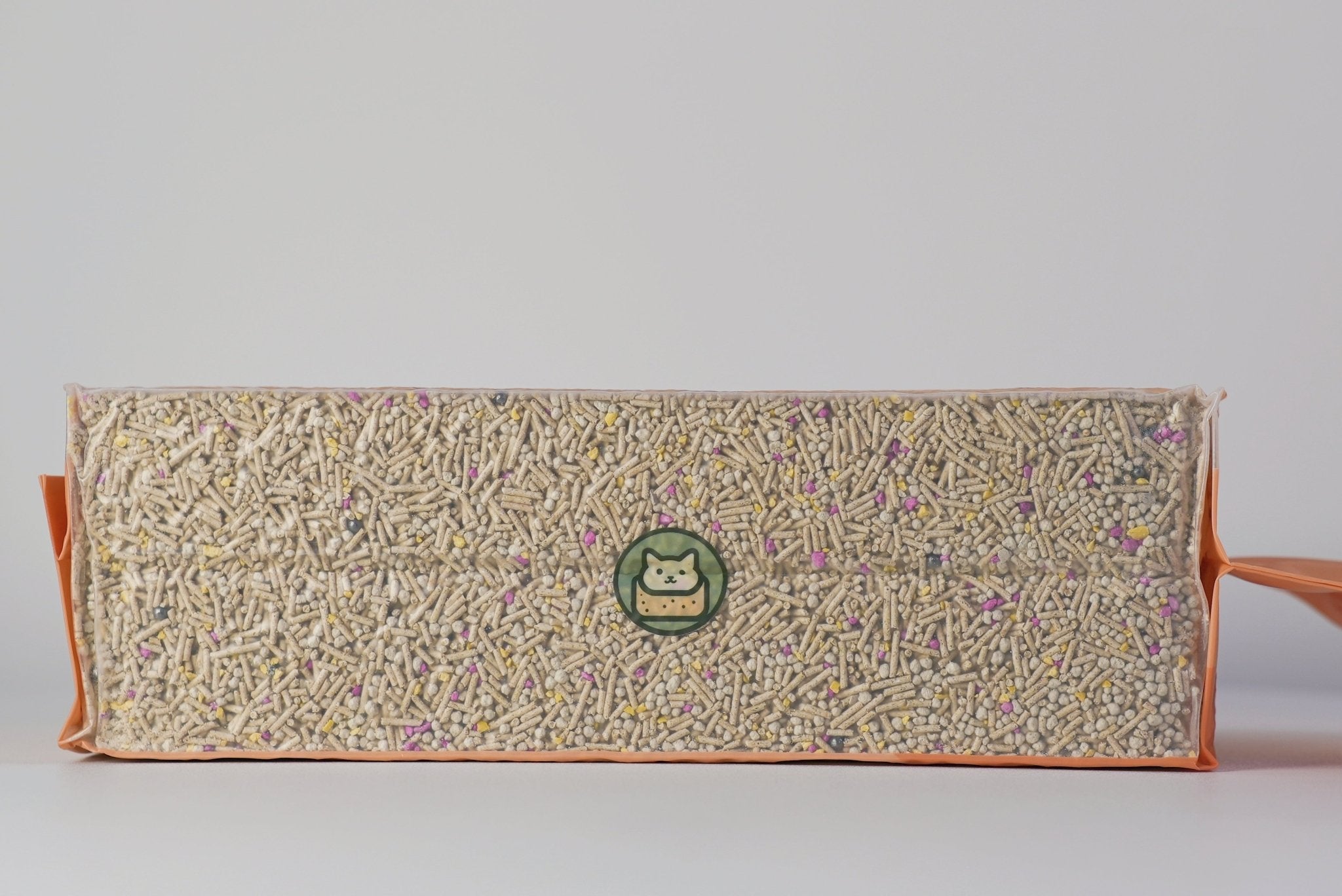 Rectangular block of cat litter and green logo on a light gray background