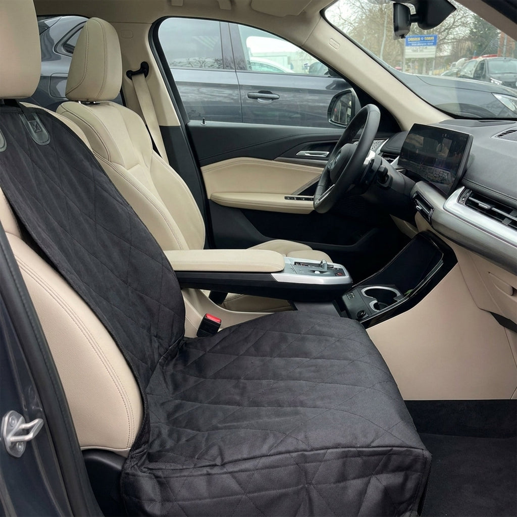 Car interior with a black seat cover on the driver's seat