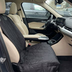 Car interior with a black seat cover on the driver's seat