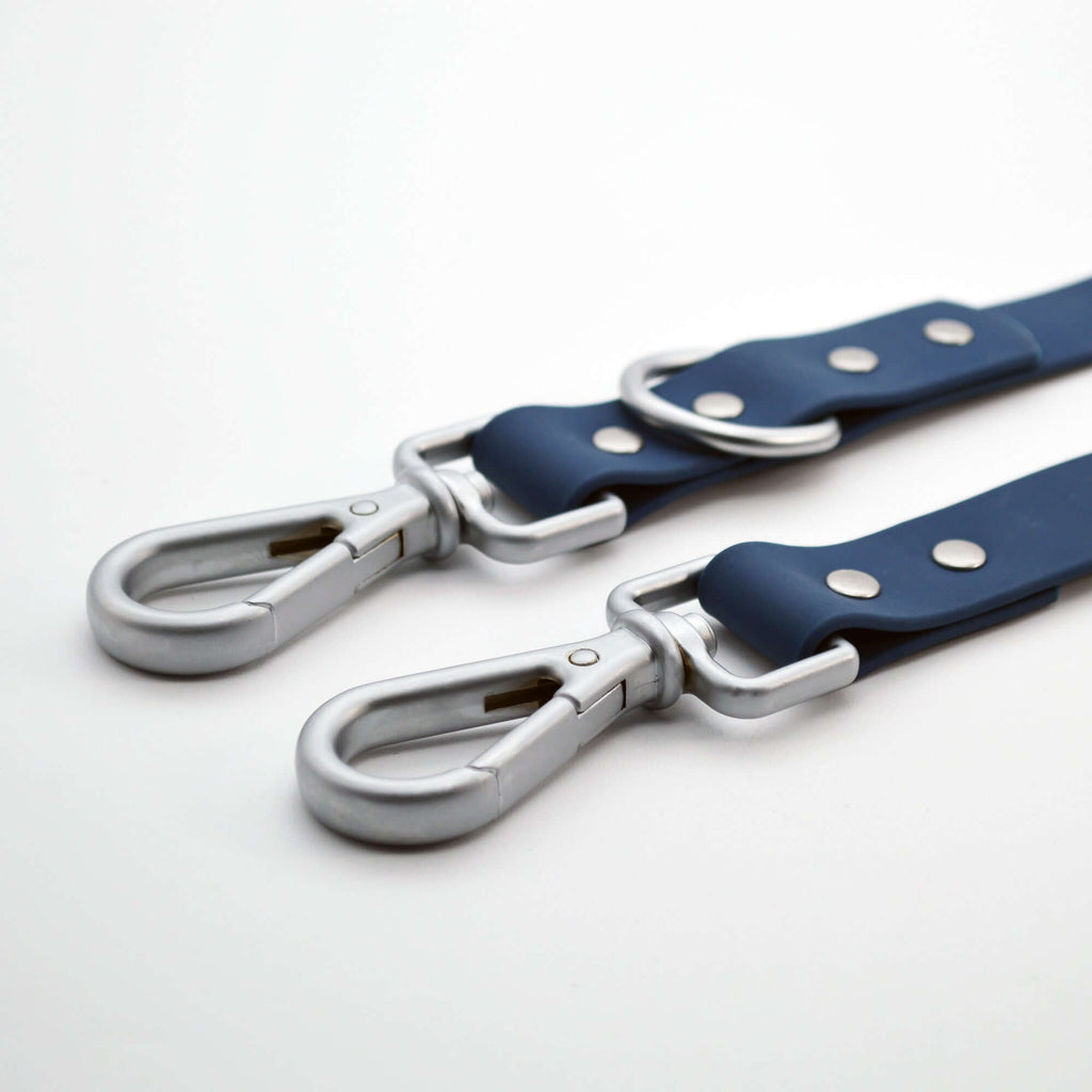 Two blue dog leash with silver hardware on a white background