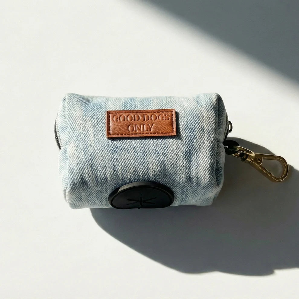 Denim dog waste bag holder with 'Good Dogs Only' label on a light background