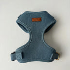 Blue dog harness with a brand label on a light gray background