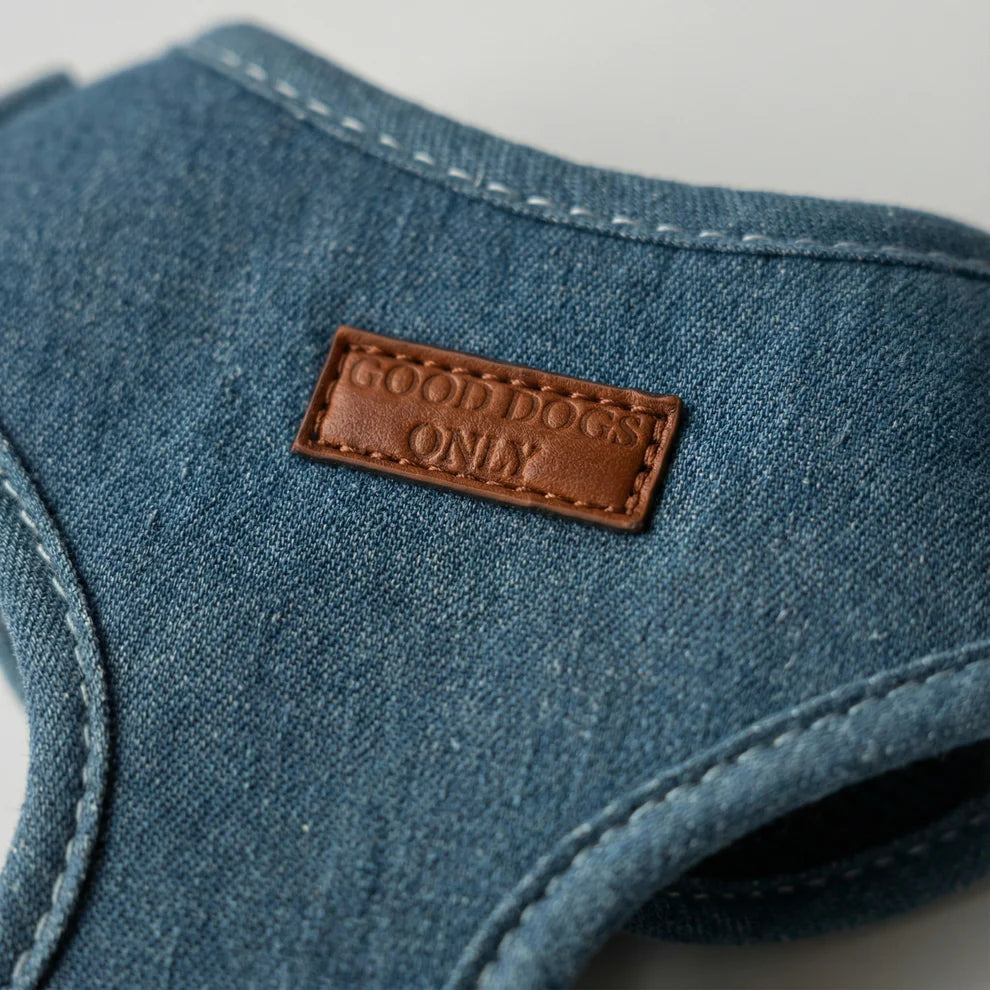 Blue denim dog harness with a brown leather label reading 'GOOD DOGS ONLY' on a white background