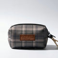 Plaid dog waste bag holder with 'Good Dogs Only' tag on a light gray background