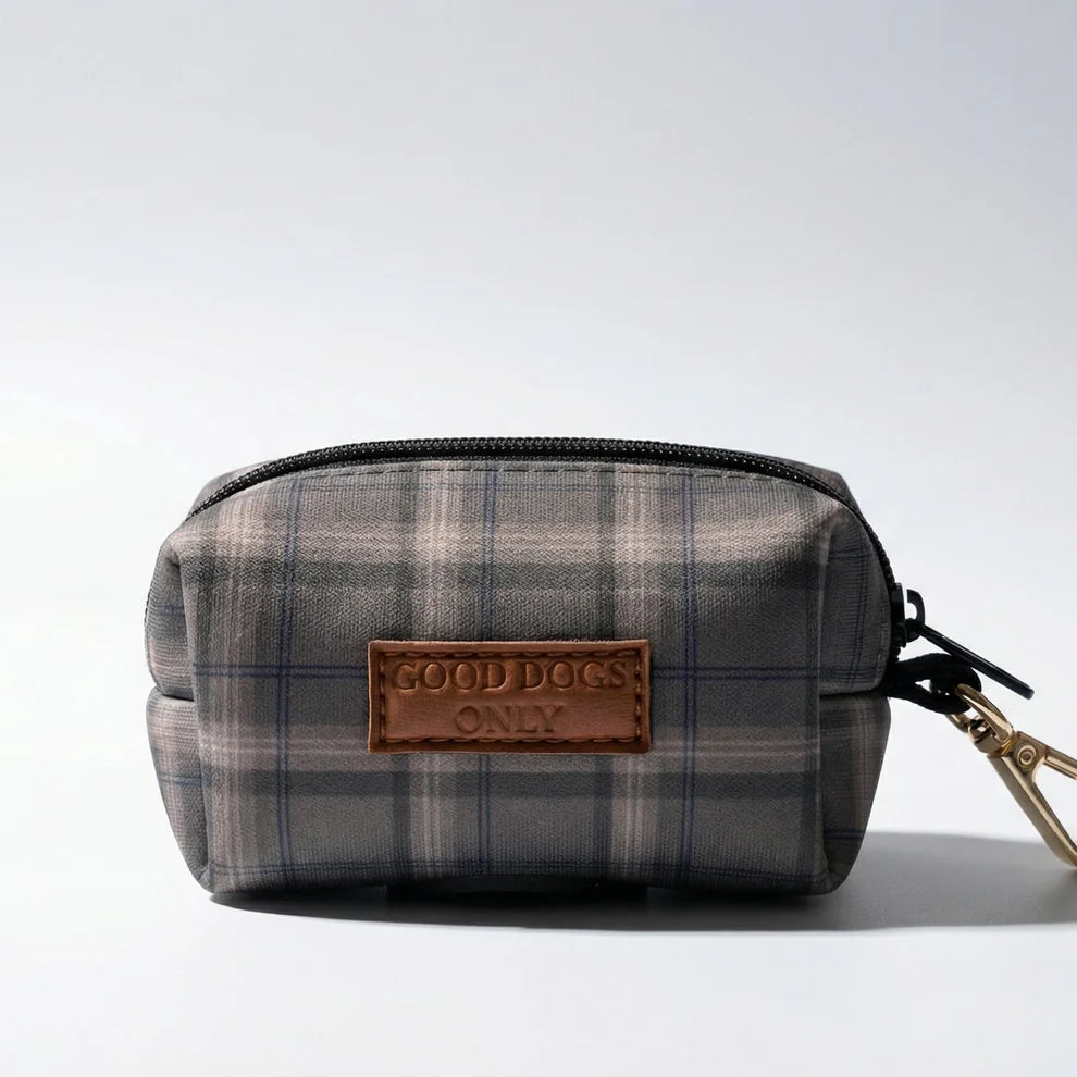 Plaid dog waste bag holder with 'Good Dogs Only' tag on a light gray background