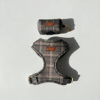 Plaid dog harness and a dog waste bag pouch on a light gray background