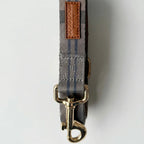 Dog leash with gold clasp and plaid pattern on a white background