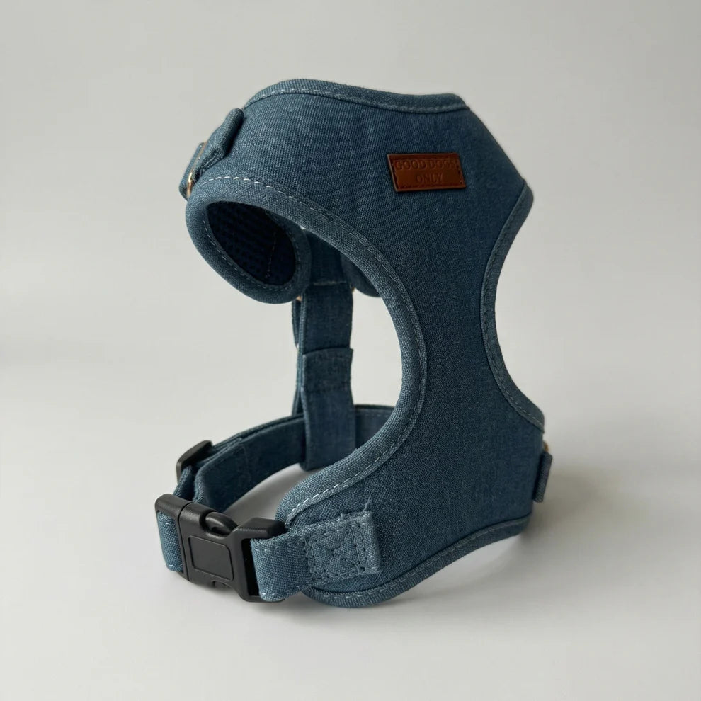 Blue denim dog harness on a light gray background