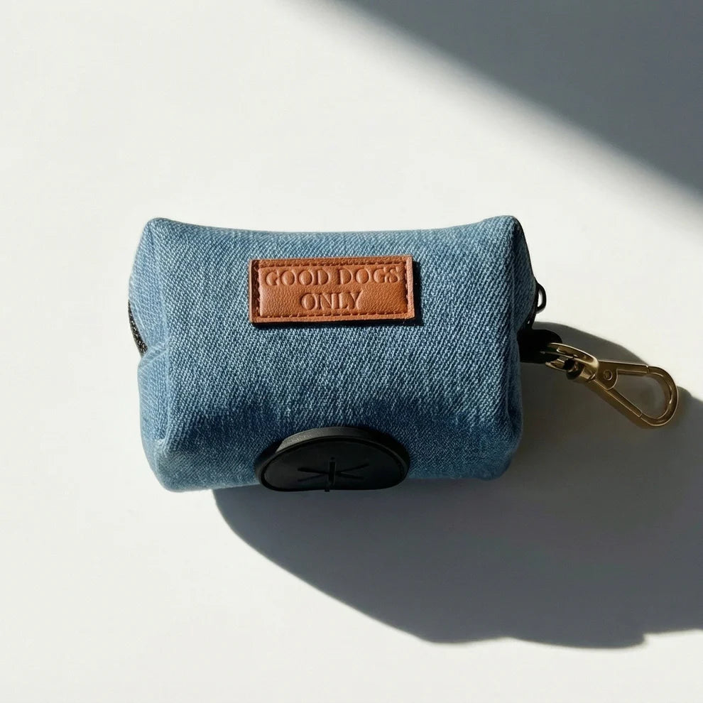 Blue dog waste bag dispenser with 'Good Dogs Only' label on a light background